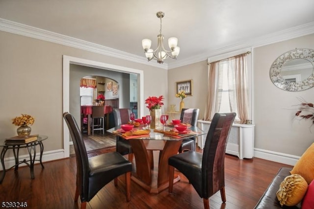 dining room featuring baseboards, ornamental molding, a chandelier, and wood finished floors