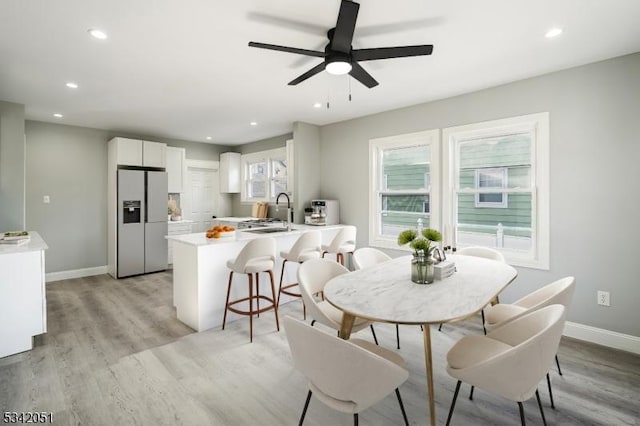 dining room with recessed lighting, baseboards, and light wood finished floors