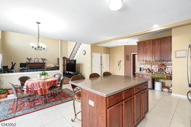 kitchen with a chandelier, backsplash, a breakfast bar area, and light tile patterned flooring