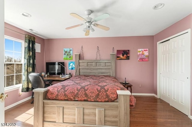 bedroom featuring a closet, a ceiling fan, baseboards, and wood finished floors