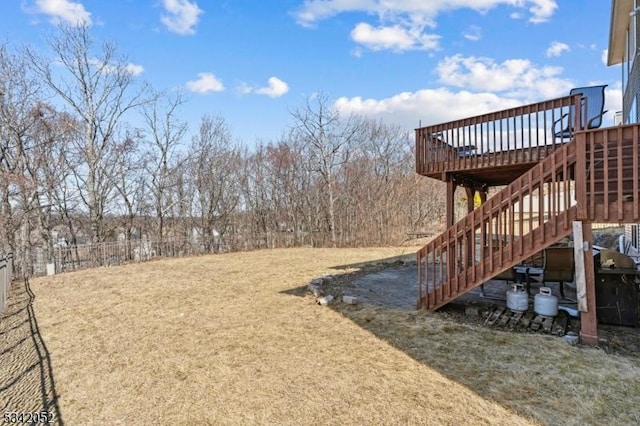 view of yard featuring stairway, a deck, and fence