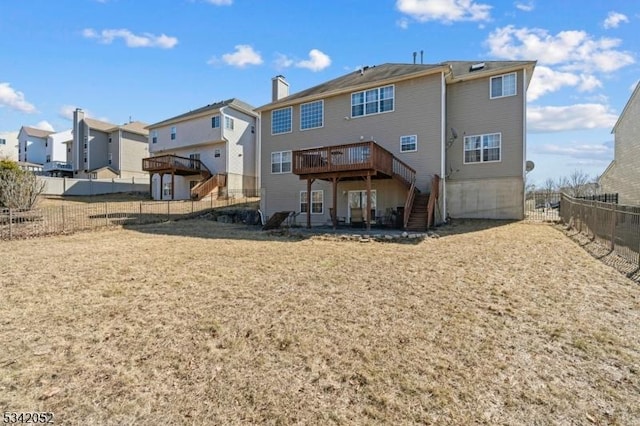 rear view of house featuring a deck, a chimney, stairs, and a fenced backyard