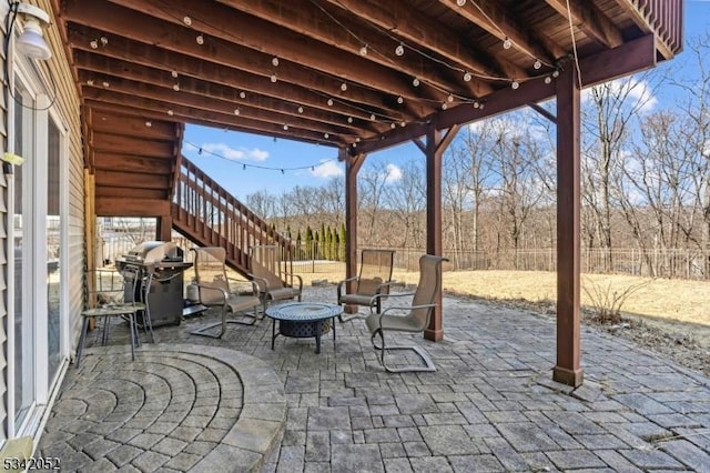 view of patio / terrace with stairway, a grill, a fire pit, and a fenced backyard