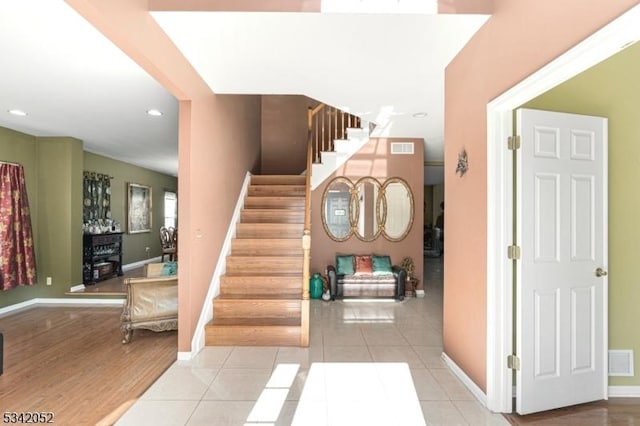 stairs featuring tile patterned flooring, visible vents, and baseboards