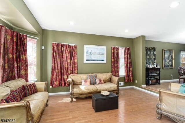 living area featuring recessed lighting, light wood-style flooring, visible vents, and baseboards