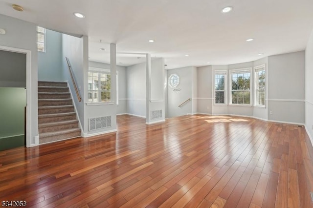 unfurnished living room featuring wood-type flooring, visible vents, and recessed lighting