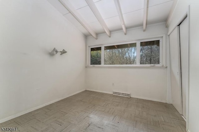 empty room featuring beamed ceiling, baseboards, and visible vents