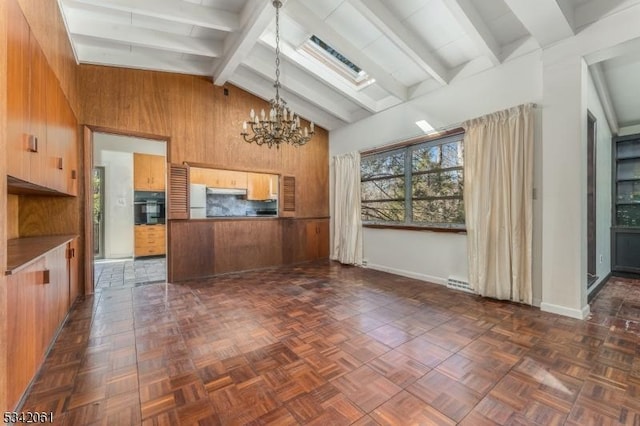 kitchen featuring high vaulted ceiling, beam ceiling, oven, wood walls, and a chandelier