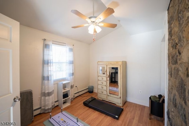 workout room with a baseboard heating unit, vaulted ceiling, wood finished floors, and a ceiling fan