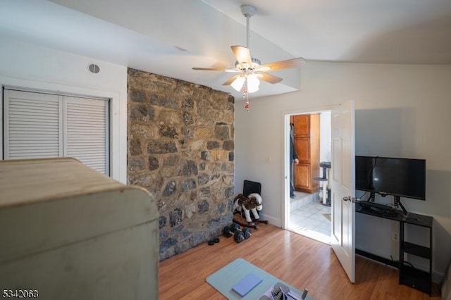 bedroom featuring a ceiling fan, lofted ceiling, and wood finished floors