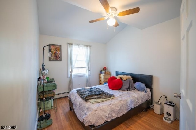 bedroom with lofted ceiling, wood finished floors, baseboard heating, and ceiling fan