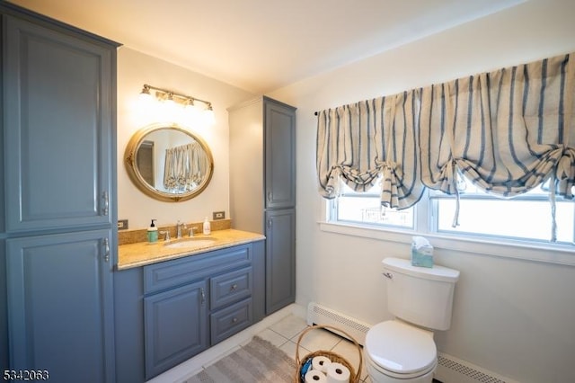 bathroom featuring a baseboard heating unit, toilet, vanity, and tile patterned flooring