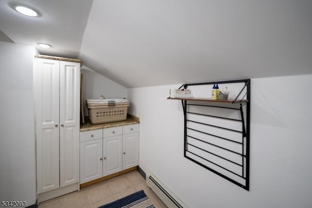 bathroom with tile patterned flooring, lofted ceiling, and a baseboard heating unit