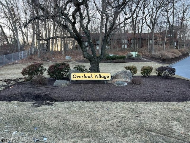 community / neighborhood sign featuring fence