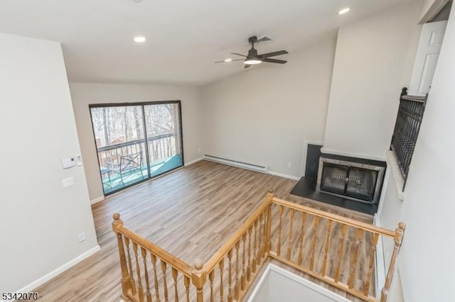 living area with wood finished floors, baseboards, recessed lighting, ceiling fan, and baseboard heating