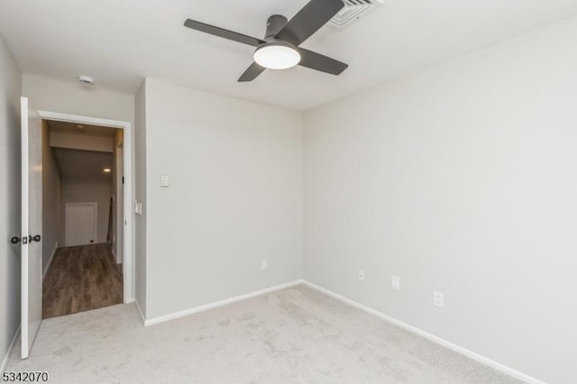 unfurnished bedroom featuring visible vents, light colored carpet, baseboards, and ceiling fan