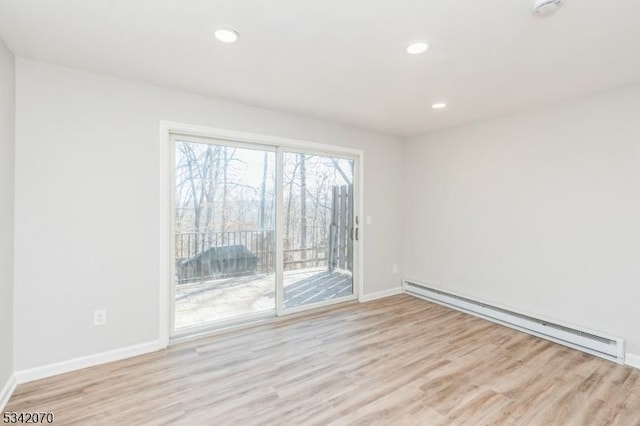 spare room with recessed lighting, light wood-type flooring, baseboards, and baseboard heating