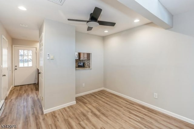 spare room featuring recessed lighting, baseboards, and light wood finished floors