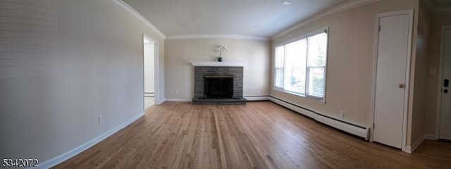 unfurnished living room featuring baseboard heating, a fireplace, baseboards, and ornamental molding