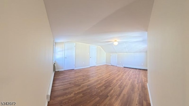 bonus room featuring a baseboard radiator, baseboards, lofted ceiling, and wood finished floors