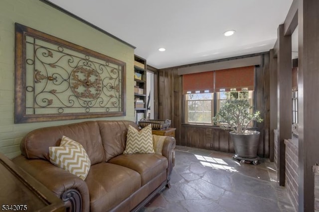 living room with stone finish floor, wooden walls, and recessed lighting