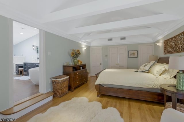 bedroom with light wood-style flooring, visible vents, and beam ceiling