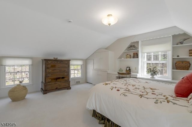 bedroom with vaulted ceiling, visible vents, and carpet