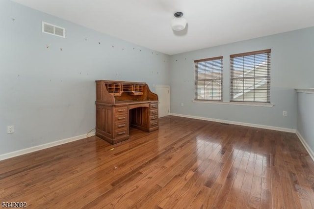 unfurnished office featuring light wood-style flooring, visible vents, and baseboards