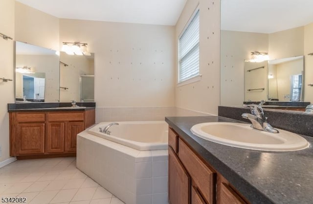 full bathroom with a garden tub, tile patterned flooring, two vanities, a sink, and a stall shower