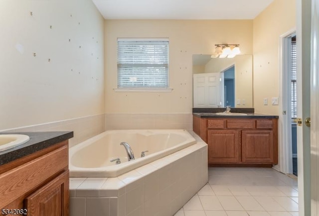 full bathroom with a bath, vanity, and tile patterned floors