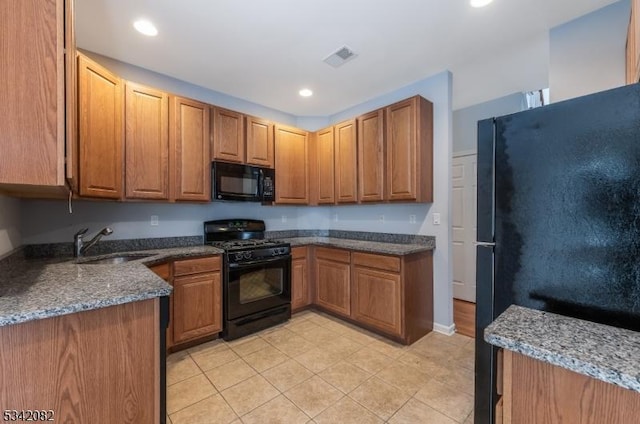 kitchen with visible vents, brown cabinets, black appliances, a sink, and recessed lighting