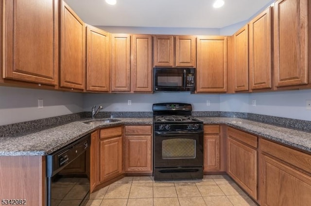 kitchen featuring brown cabinetry, a sink, black appliances, and light tile patterned floors