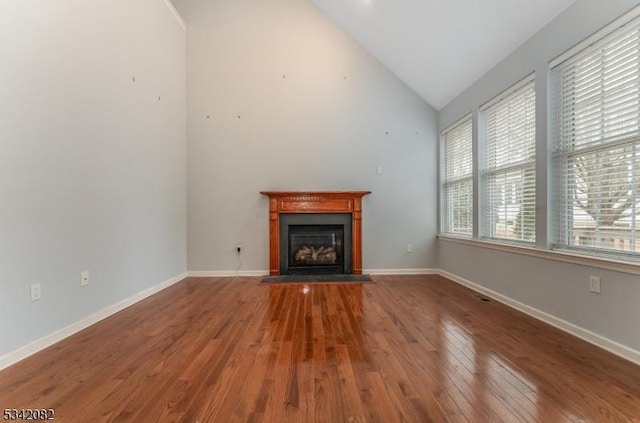 unfurnished living room featuring a fireplace with flush hearth, vaulted ceiling, baseboards, and hardwood / wood-style flooring