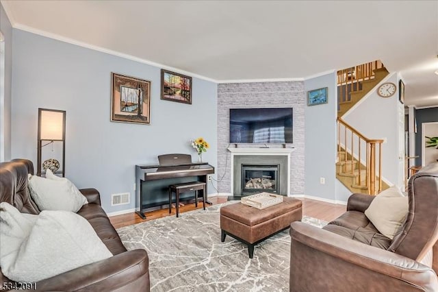 living room featuring stairs, wood finished floors, visible vents, and crown molding