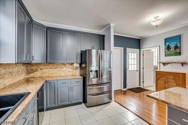 kitchen with dishwasher, crown molding, backsplash, and stainless steel fridge with ice dispenser