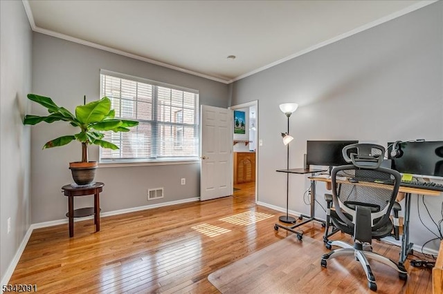 home office featuring ornamental molding, baseboards, visible vents, and hardwood / wood-style floors