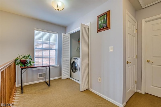 washroom with laundry area, visible vents, baseboards, light colored carpet, and washer / clothes dryer