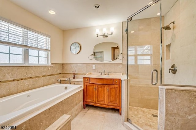 bathroom with a stall shower, vanity, a bath, and tile patterned floors