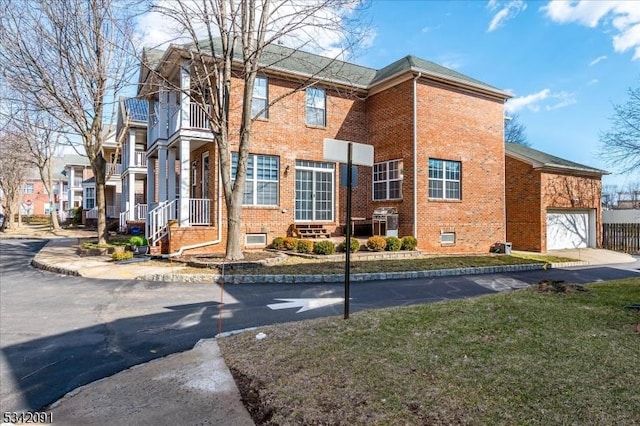 view of side of home with a balcony and brick siding