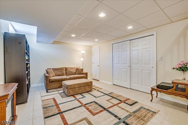 living area featuring recessed lighting, light tile patterned flooring, a paneled ceiling, and baseboards