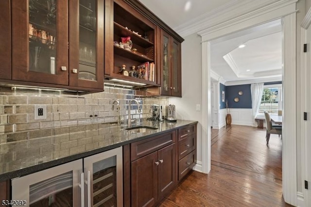 bar featuring beverage cooler, a sink, ornamental molding, indoor wet bar, and dark wood finished floors