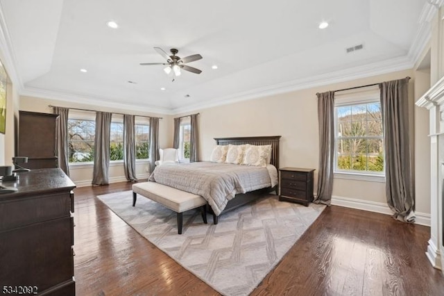 bedroom featuring hardwood / wood-style flooring, a raised ceiling, visible vents, and crown molding