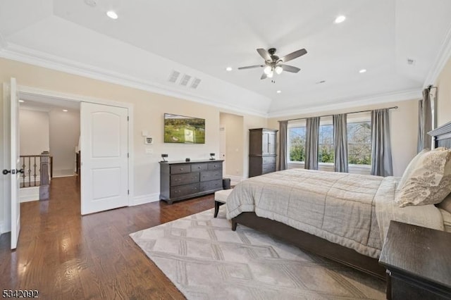 bedroom featuring a tray ceiling, crown molding, recessed lighting, wood finished floors, and baseboards