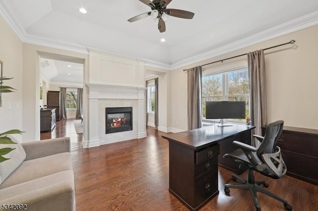 home office with crown molding, recessed lighting, dark wood-type flooring, a glass covered fireplace, and ceiling fan