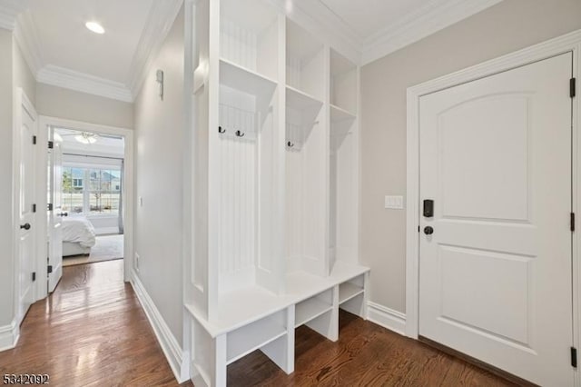 mudroom with dark wood-style floors, crown molding, and baseboards