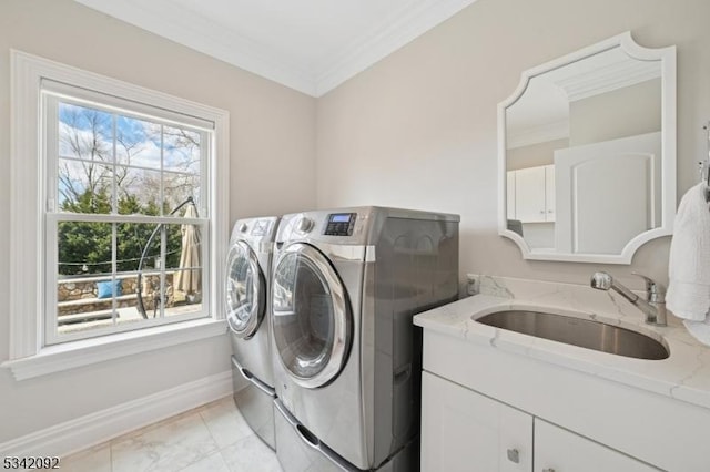 clothes washing area with ornamental molding, baseboards, a sink, and washing machine and clothes dryer