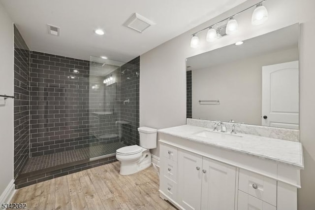 full bathroom featuring a walk in shower, toilet, wood finished floors, vanity, and visible vents