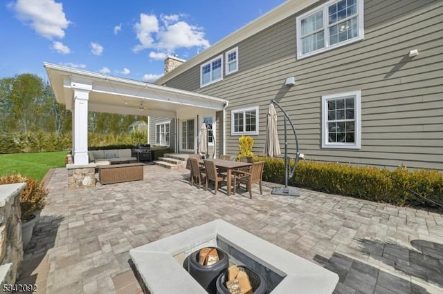 view of patio featuring entry steps, outdoor dining area, and an outdoor living space with a fire pit