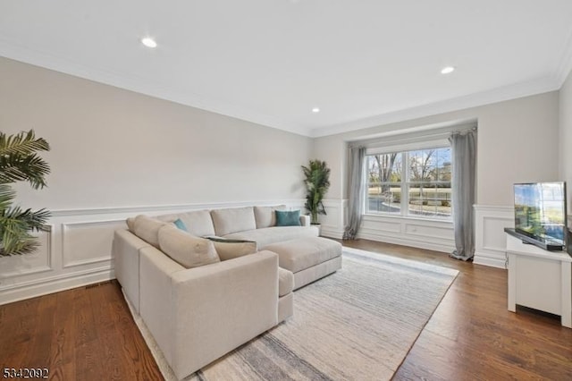 living area featuring wainscoting, wood finished floors, crown molding, a decorative wall, and recessed lighting