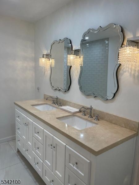 bathroom with double vanity, tile patterned flooring, and a sink